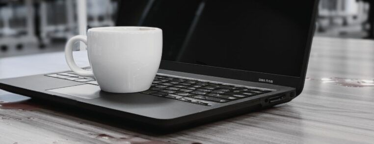 wylana kawa na stole obok laptopa potencjalna awaria laptopa